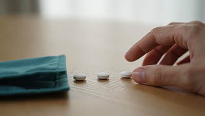 На столе лежат таблетки и платок